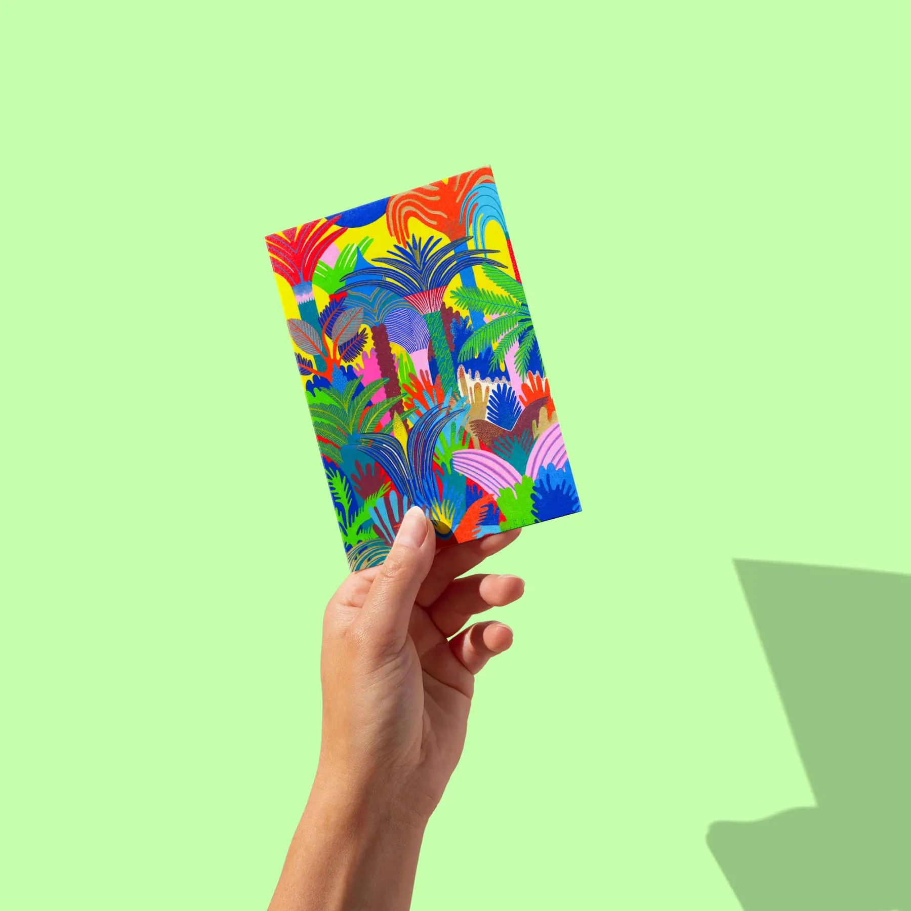 Jungle dense de palmiers et feuillages aux couleurs vives sur fond jaune et bleu, carte postale illustrée par Orane Sigal
