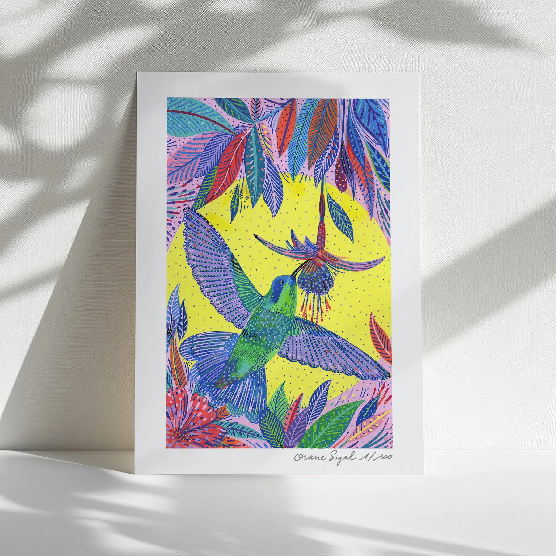 Colibri vert et bleu butinant une fleur tubulaire sur fond jaune et feuillages violets, tirage d'art illustré par Orane Sigal