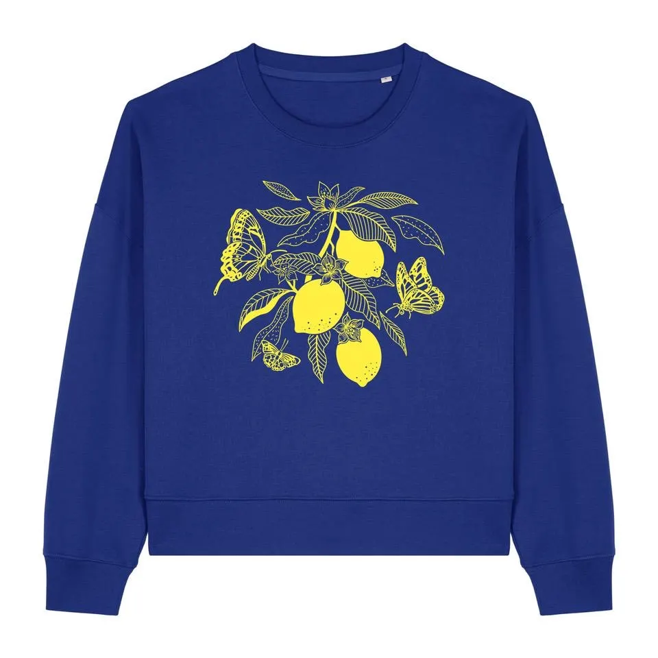 Branche de citronnier jaune et papillon dorés sur fond violet, sweat illustré par Orane Sigal