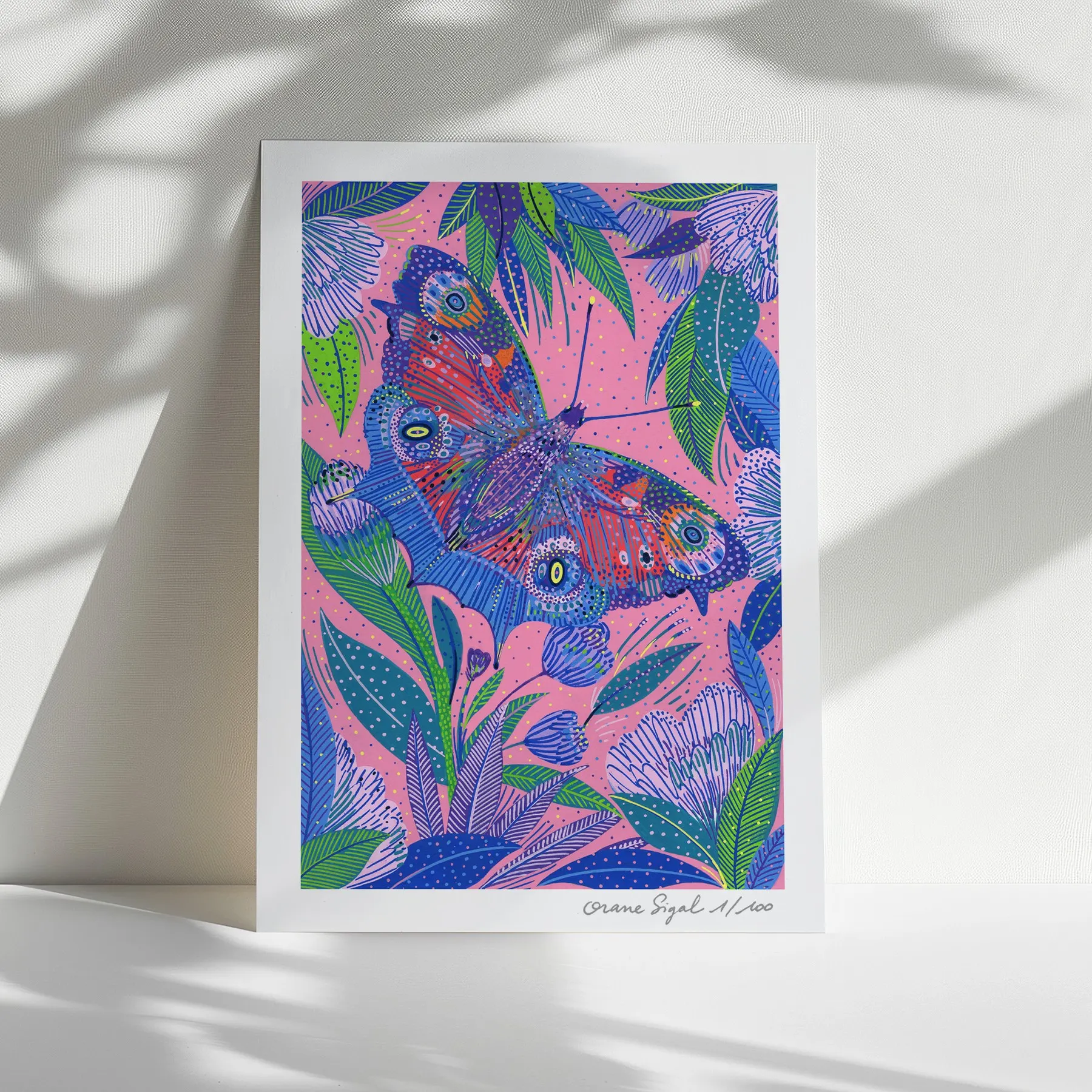 Grand papillon rouge et bleu aux ailes ocellées parmi des feuillages sur fond rose, tirage d'art illustré par Orane Sigal