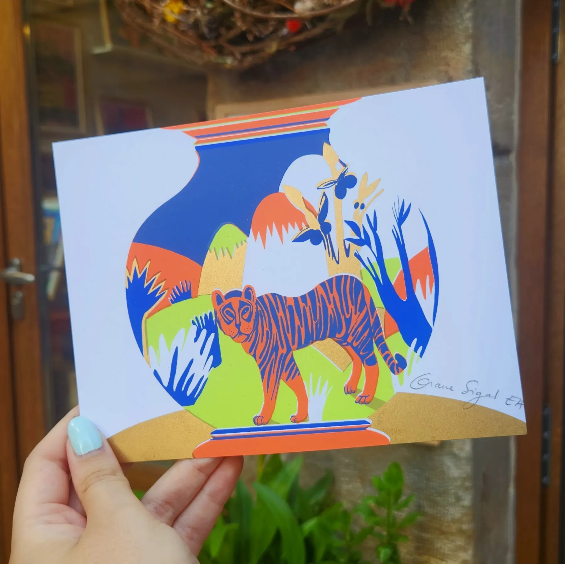 Tigre rose et bleu debout sur des feuillages tropicaux, fond blanc, illustration par Orane Sigal
